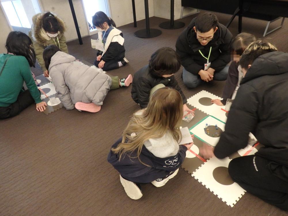 日本語学校の学生と一緒にキャロムを楽しむ子どもたち