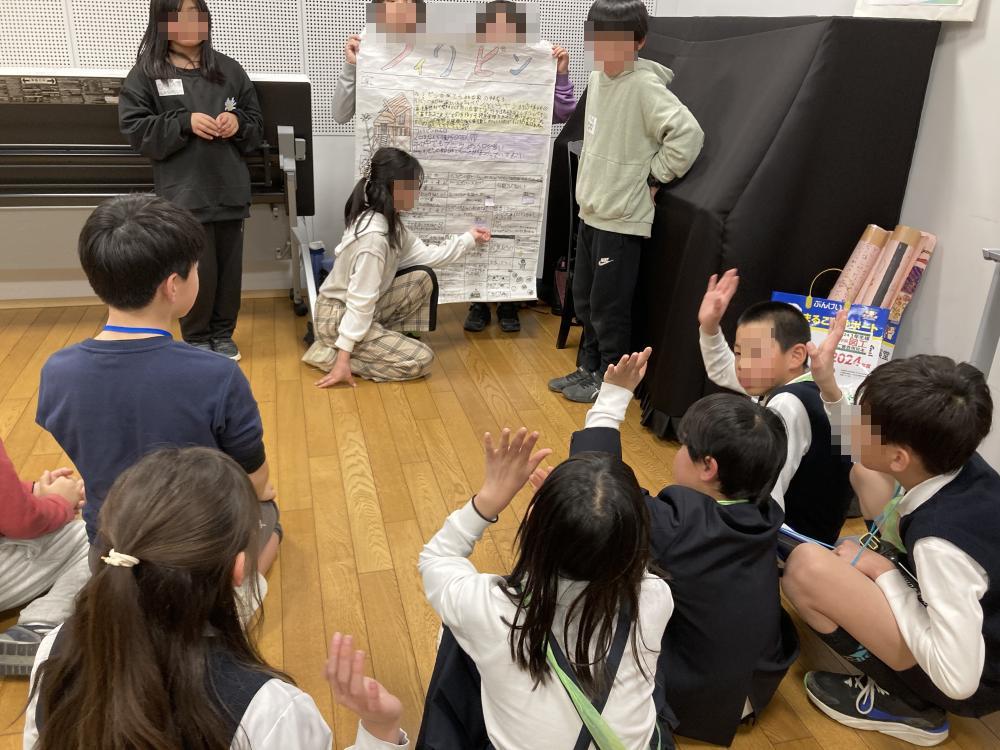 クイズに答えようと手を挙げている子どもたち